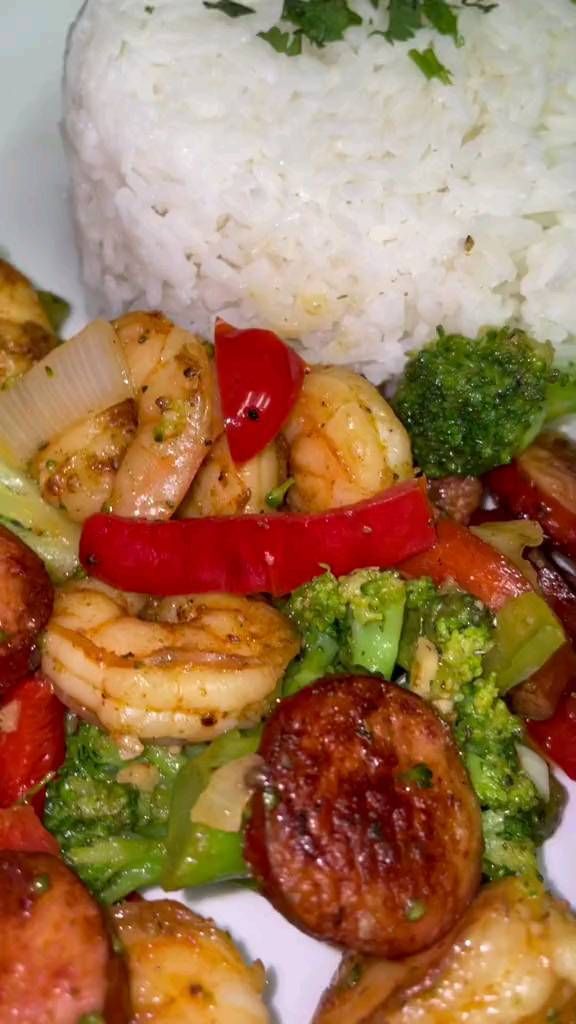 shrimp, broccoli, and peppers with rice on a plate