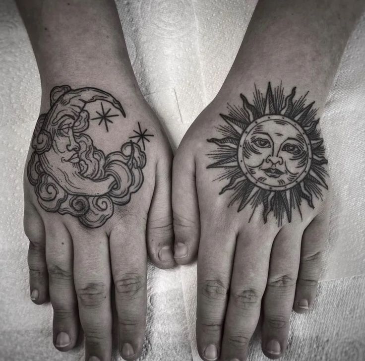 two hands with sun and moon tattoos on them