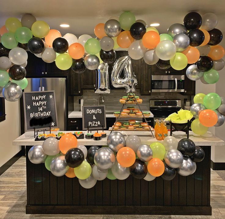 a birthday party with balloons and cake on the counter in front of an open kitchen