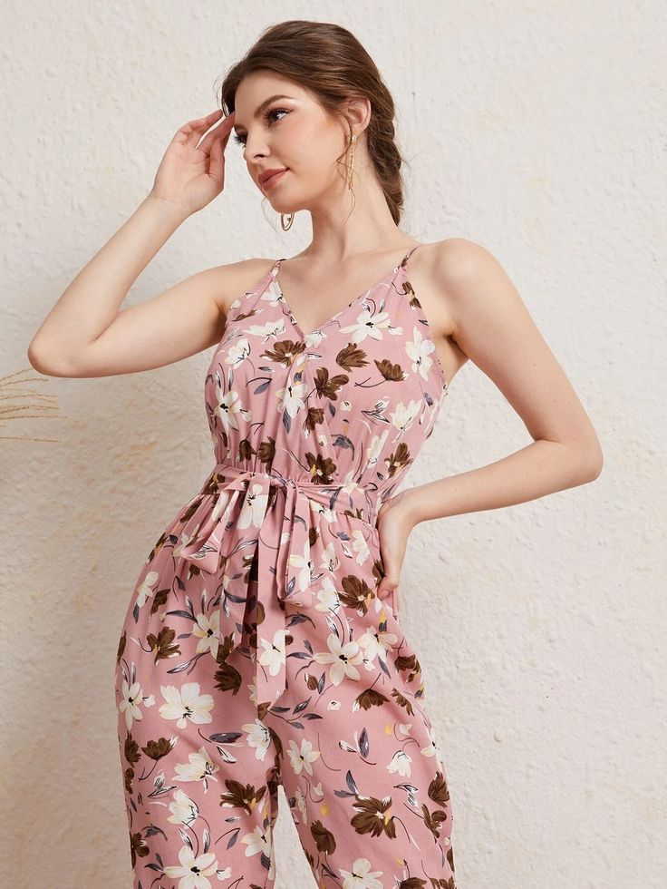 The pink base makes up any mood for an outing. The Floral Print Cami Jumpsuit also comes with a matching belt that cinches at the waist to accentuate your curves and create a flattering silhouette. The bold and vibrant floral print adds a pop of color and makes this jumpsuit perfect for any occasion, whether it's a brunch date with friends or a day out exploring the city. Features: Pattern Type: Floral, All Over Print Details: Belted, Wrap Length: Capris Type: Cami Fit Type: Regular Fit Neckline Romper Casual, Stylish Maxi Dress, Comfy Jumpsuits, Cami Jumpsuit, Fitted Maxi Dress, Casual Rompers, Boho Patterns, Waist Pants, Jumpsuits For Women