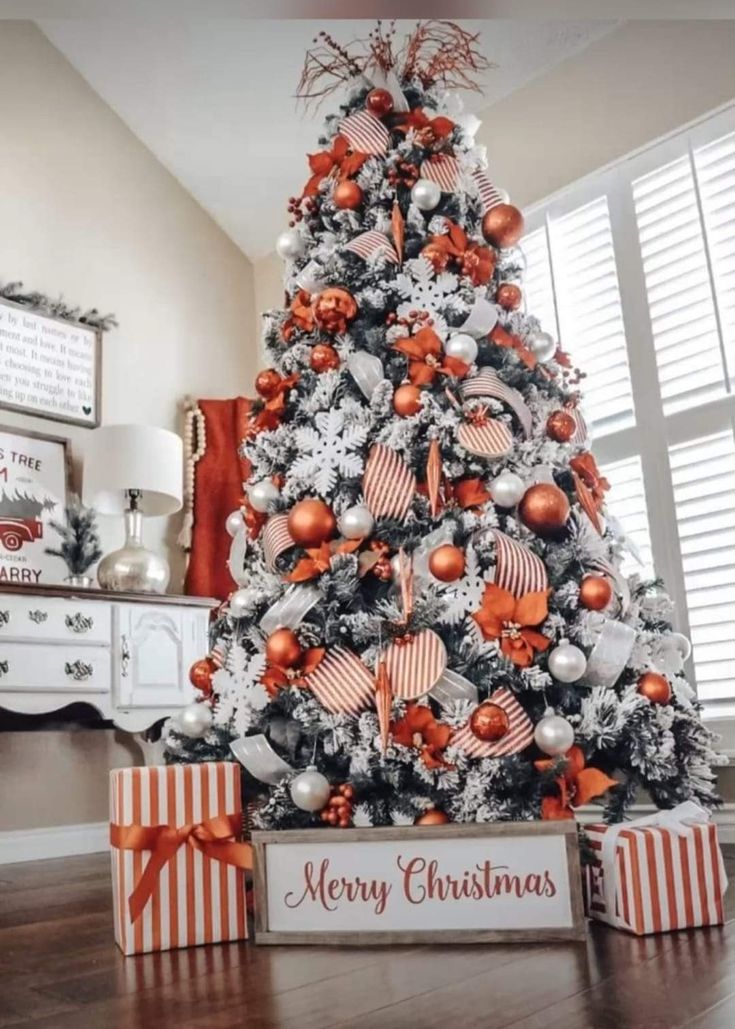 a christmas tree decorated with orange and silver ornaments