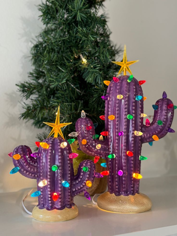 a purple cactus with lights on it next to a christmas tree