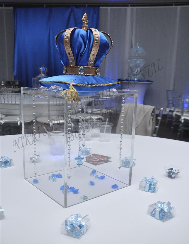 a table topped with lots of blue dice and a large crown on top of it