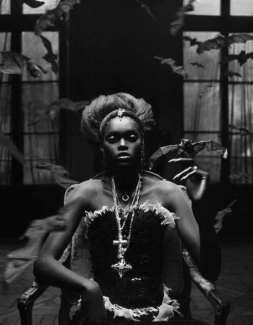 a woman sitting in a chair with feathers on her head