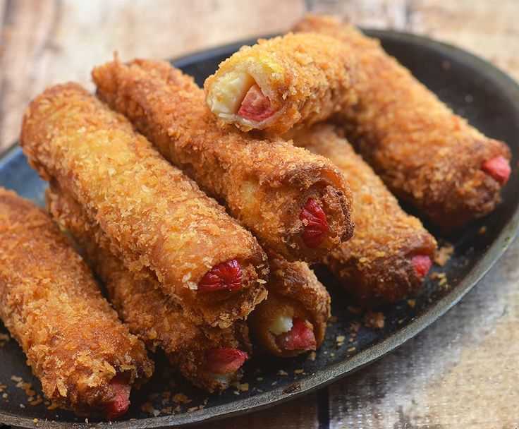 some fried food on a black plate with seasoning and pepper sprinkles