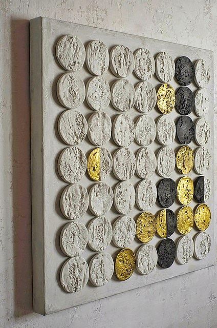 a white and yellow wall hanging on the side of a building with circles painted on it