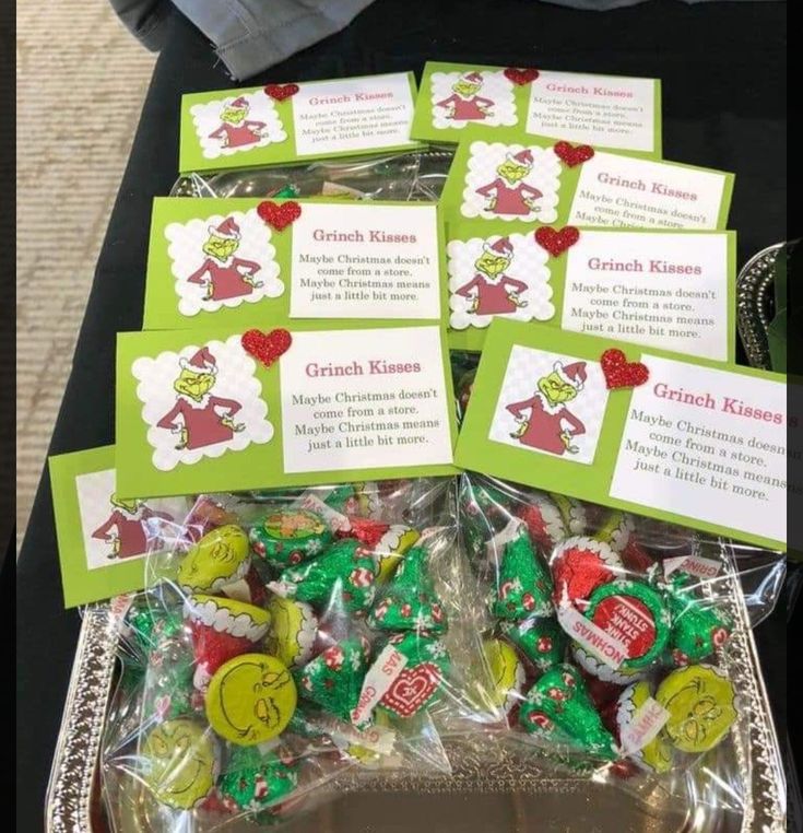 there are many candy candies in the tray on the table with name tags attached to them