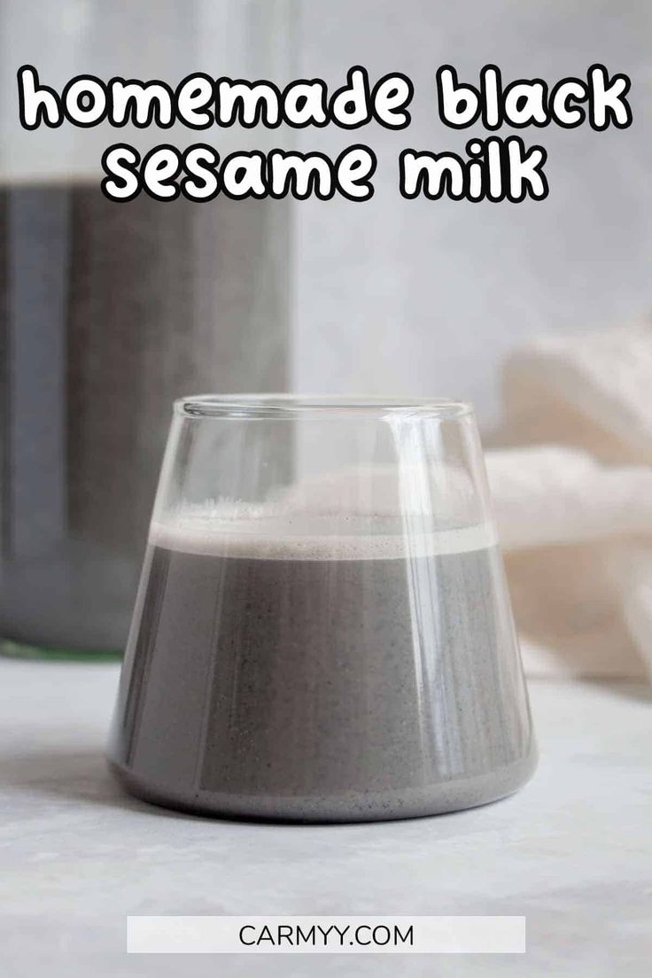 homemade black sesame milk in a glass on a table with the words, homemade black sesame milk