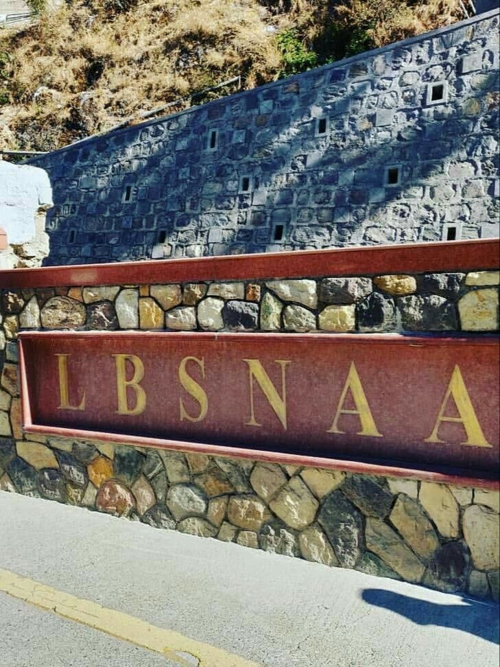 there is a sign that says llbsna on the side of a stone wall