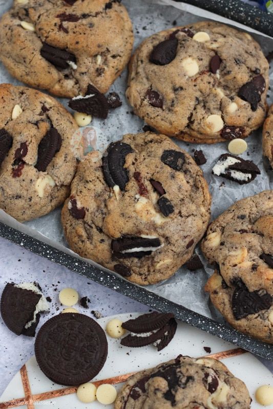 chocolate chip cookies and oreo cookies are sitting on a baking sheet, ready to be eaten