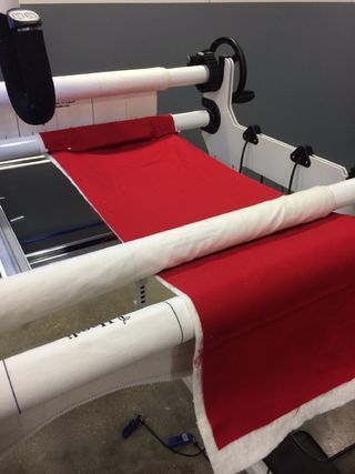 a red and white machine that is cutting fabric on it's sides with scissors