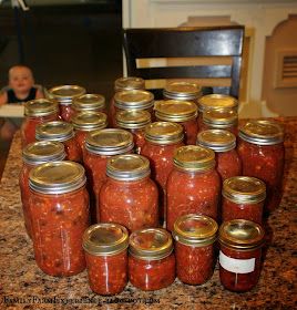 there are many jars of food sitting on the counter top with a baby in the background