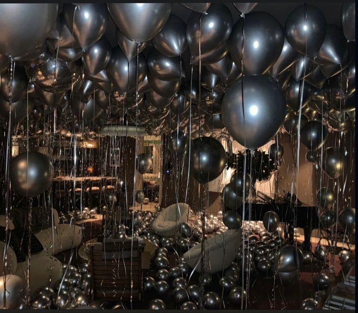 a room filled with lots of metallic balloons