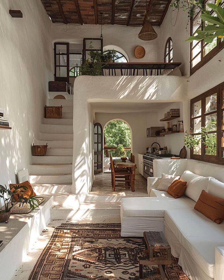 a living room filled with white furniture and lots of natural sunlight coming through the windows