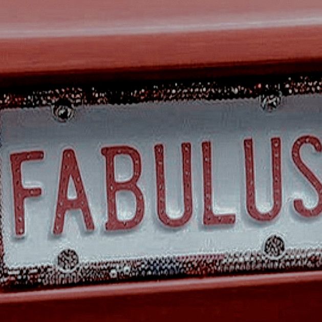 a close up of a red car with a sign that says fabulous on the front