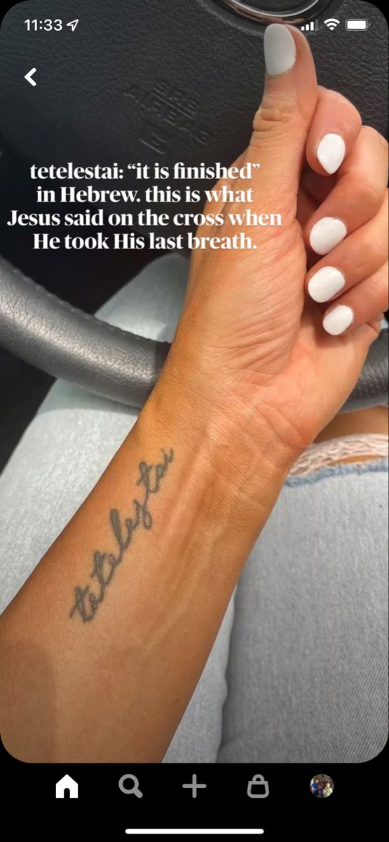 a woman's hand with a small tattoo on her wrist and the words, tetesia it is finished