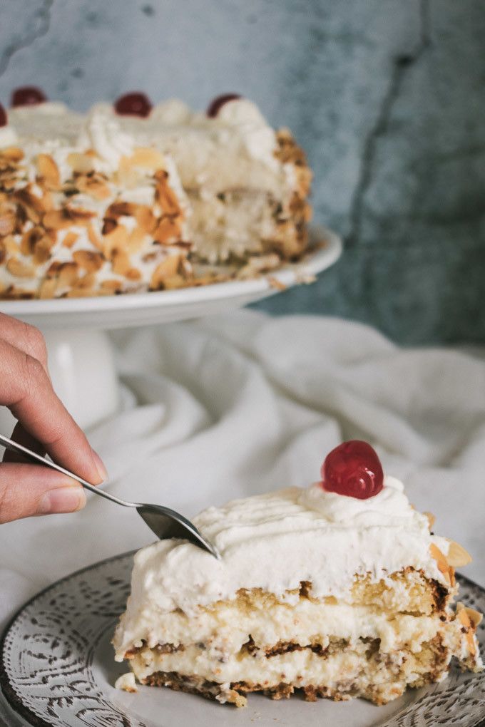 someone cutting into a piece of cake on a plate with a knife and fork in it