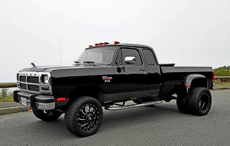 a black truck parked on the side of a road