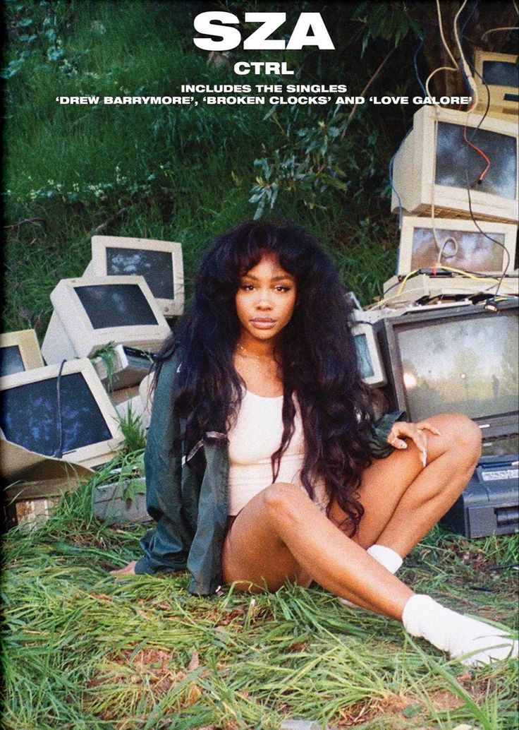 a woman sitting on the ground in front of old televisions