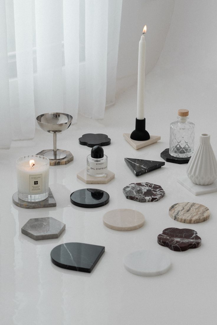 a white table topped with lots of different types of rocks and candle holders on top of it