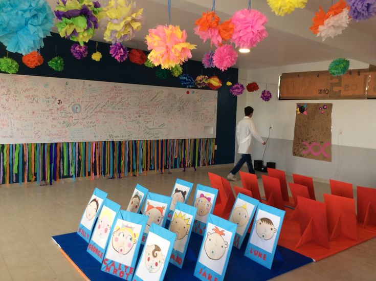 there are many cards on the table in front of some paper flowers hanging from the ceiling