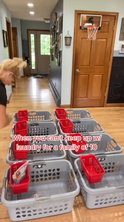 a woman standing in front of a bunch of baskets on top of a hard wood floor