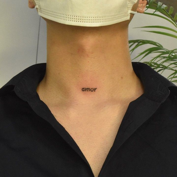 a woman wearing a face mask with the word corona tattooed on her neck