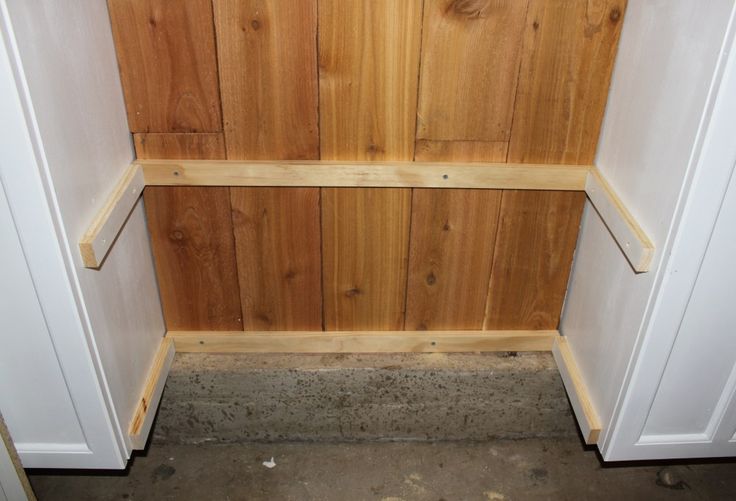 the inside of a wooden closet with white doors