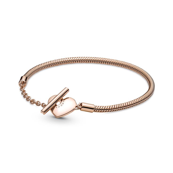 Add a warm-toned accent to your look with the Pandora Moments Heart T-Bar Snake Chain Bracelet. Hand-finished in a 14K rose gold-plated unique metal blend, this piece is an updated take on the Pandora Moments snake chain bracelet. Featuring a heart-shaped T-bar double circle closure, loop the T-bar through the smallest circle to guarantee that the bracelet clasp is securely closed. Wear this sleek, modern style with up to 10-13 Pandora Moments charms and dangles. Rose Gold Metal Bracelets With Heart Charm, Pandora Armband, Charms Pandora, Bracelet Pandora, Snake Chain Bracelets, Silver Snake Chain, Bracelet Cuir, Bar Bracelets, Gold Bracelet Chain