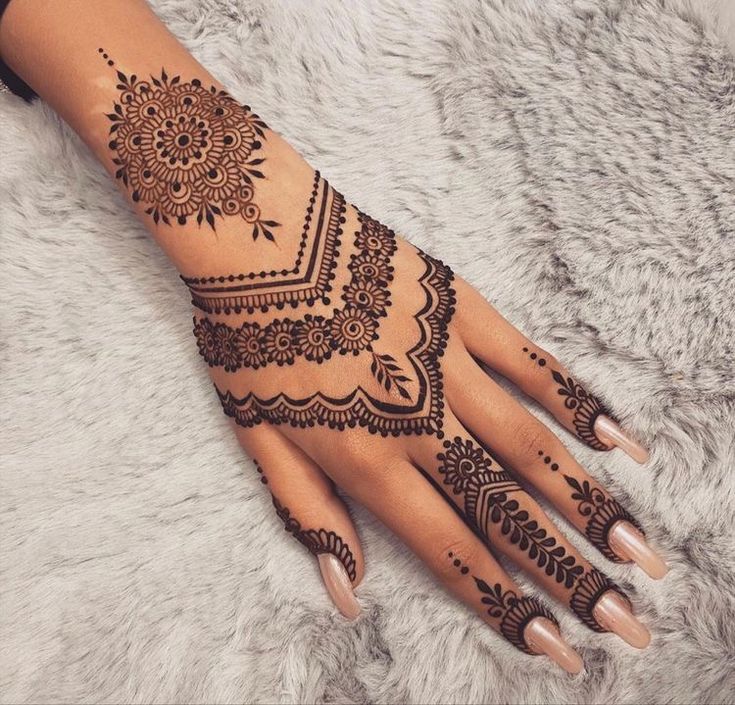 a woman's hand with henna tattoos on it