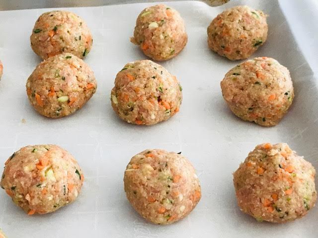 several balls of food sitting on top of a baking sheet