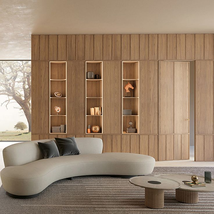 a modern living room with wood paneling and white couches, coffee table and bookshelves