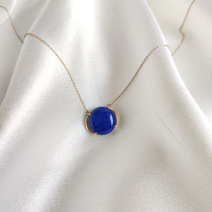 "This stunning pendant is set in 14k Solid Yellow Gold with Natural Lapis Lazuli with utmost precision. It is a unique gemstone pendant for nearly every occasion and is completely hassle-free jewelry. ITEM DETAILS: * GEM: Lapis Lazuli * GEM Size: 15X15mm * GEM Shape: Round * Gem Weight: 10.19 carats * Gold Purity: 14KT  * Gold Weight: 1.57 gram * Total Weight of the Pendant: 3.61 gram * Chain Length: 16\" with 0.5\" inch adjustable hooks The Gold purity is guaranteed and it comes with an authentic 14KT gold hallmark. Since my items are handmade, they are absolutely nickel and lead free. CUSTOMIZATION: * Gemstone customization is available and it can be substituted with a gem of your choice. Kindly message me for the same. PACKAGING * The Pendant comes with layers of safe and secure wrappin Minimalist Round Cabochon Necklaces, Minimalist Round Cabochon Necklace, Blue 14k Gold Round Pendant Necklace, Blue Minimalist Necklace For Formal Occasions, Yellow Gold Lapis Lazuli Round Necklace, Yellow Gold Lapis Lazuli Minimalist Jewelry, Yellow Gold Lapis Lazuli Necklace For Gift, Minimalist Yellow Gold Lapis Lazuli Jewelry, Formal Lapis Lazuli Round Necklace