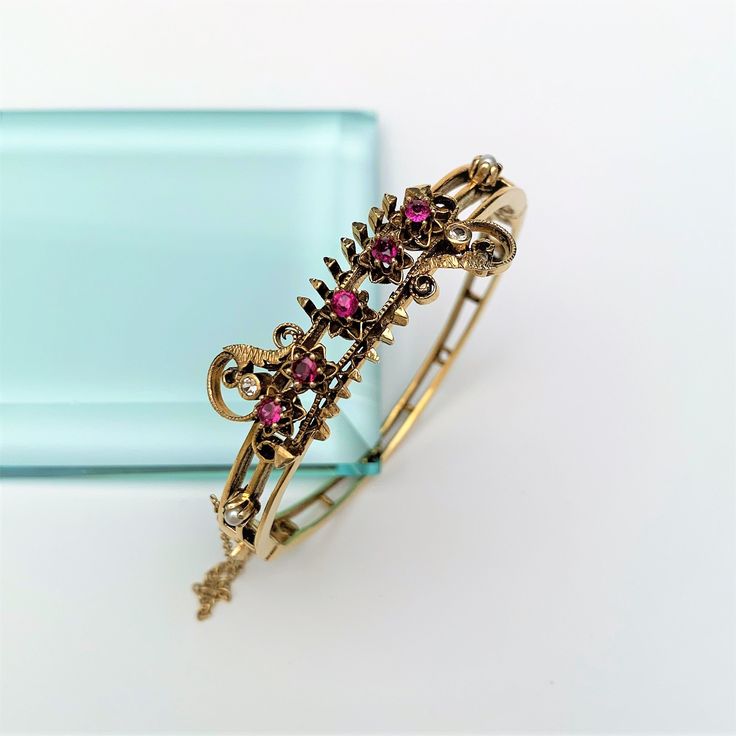 "This is a stunning Victorian era Etruscan revival hinged bangle bracelet. The piece is made of 14k gold and set with 2 round, single cut diamonds (2.15mm each), five remixed cut rubies (.65 ct.), and 2 cultured pearls. The bracelet has a locking closure with a safety chain. The piece is in excellent vintage condition with no visible flaws. The bracelet measures 2.1\" wide at the center, and weighs 21.6 grams. There is an appraisal included. If you have any questions or would like to see additio Antique Yellow Gold Bangle For Formal Occasions, Vintage Single Cut Diamond Bangle, Victorian Gold Bangle Bracelet For Formal Events, Vintage Bangle Bracelet With Single Cut Diamonds, Victorian Gold Bracelet For Formal Occasions, Heirloom Yellow Gold Diamond Bracelet, Formal 14k Gold Filigree Bracelets, Heirloom Hallmarked Bangle Jewelry, Antique 17 Jewels Bracelet For Anniversary