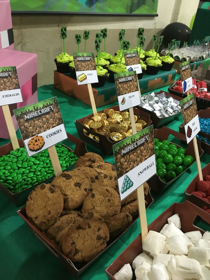 a table filled with lots of different types of cookies and marshmallows on sticks