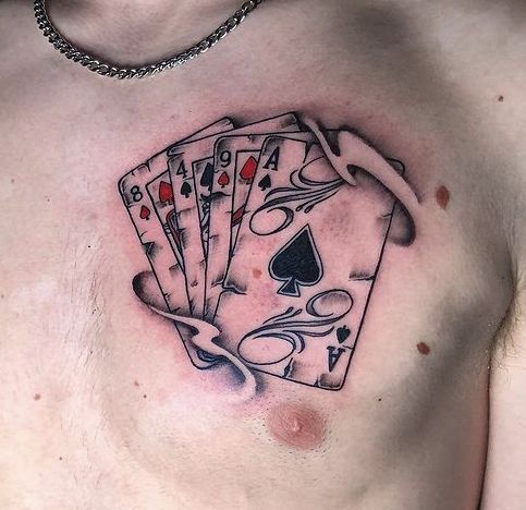 a man with four cards tattoo on his chest