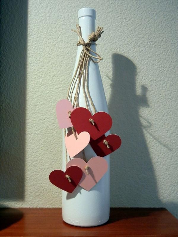 a bottle with hearts attached to it sitting on a table