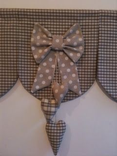 a decorative bow hangs on the back of a headboard made out of plaid fabric