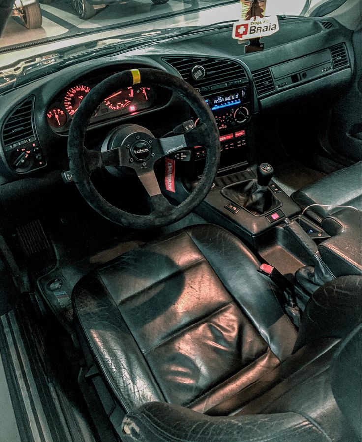 the interior of a car with black leather seats and dashboards, including steering wheel