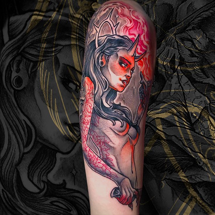 a woman's arm with a tattoo on it and an image of a demon