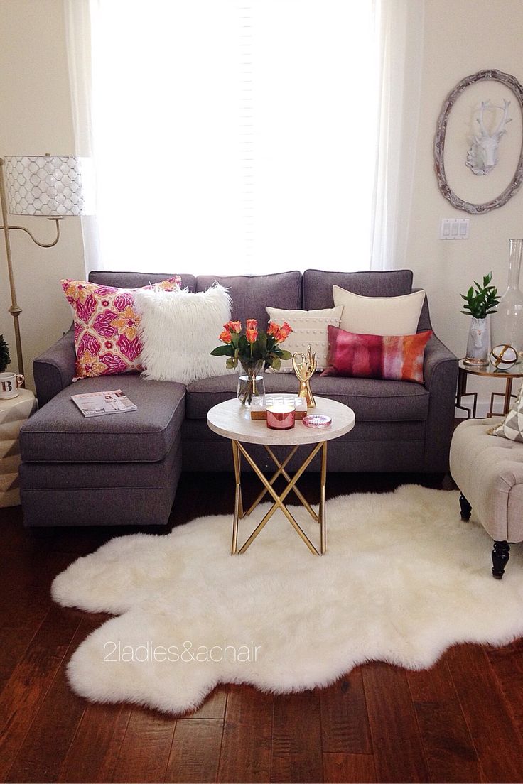 a living room filled with lots of furniture next to a white rug on top of a hard wood floor