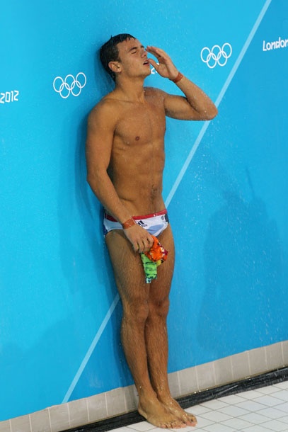 a man standing in front of a swimming pool with his hand on his face and mouth