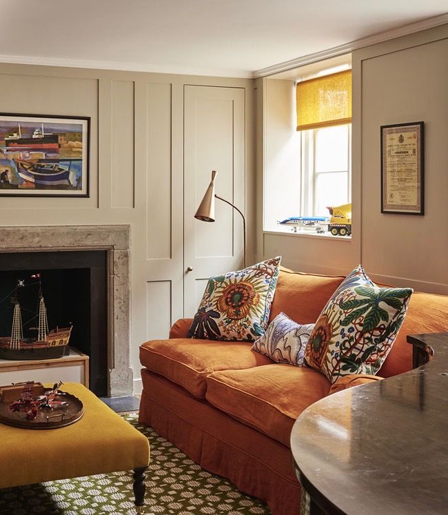 a living room filled with furniture and a fire place under a painting on the wall