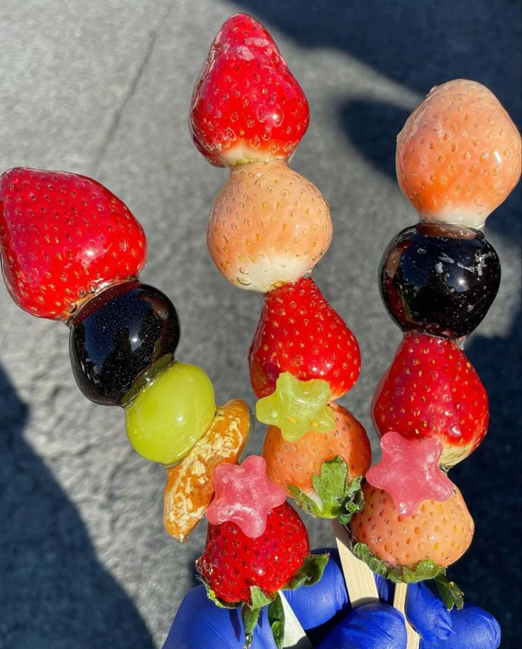 a person holding up a bunch of fruit on top of each other in their hand