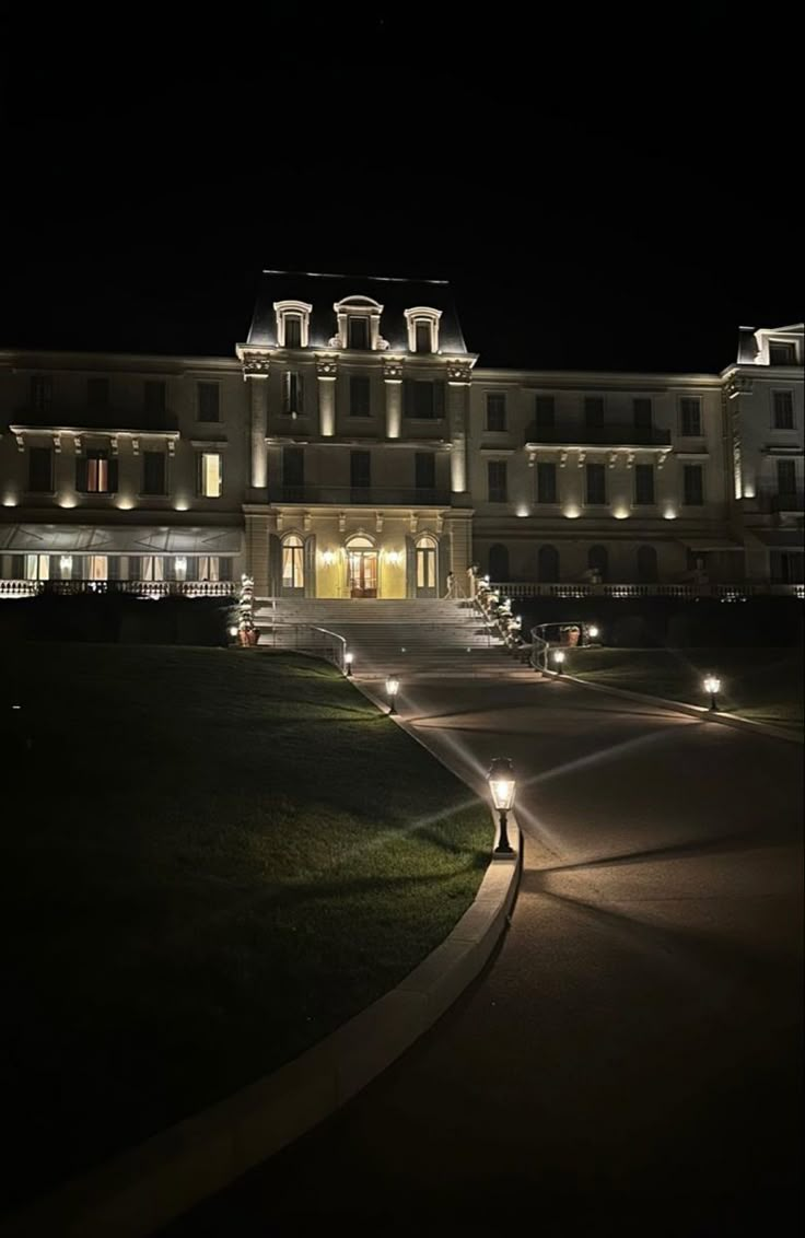 a large building lit up at night with lights on the front and side of it