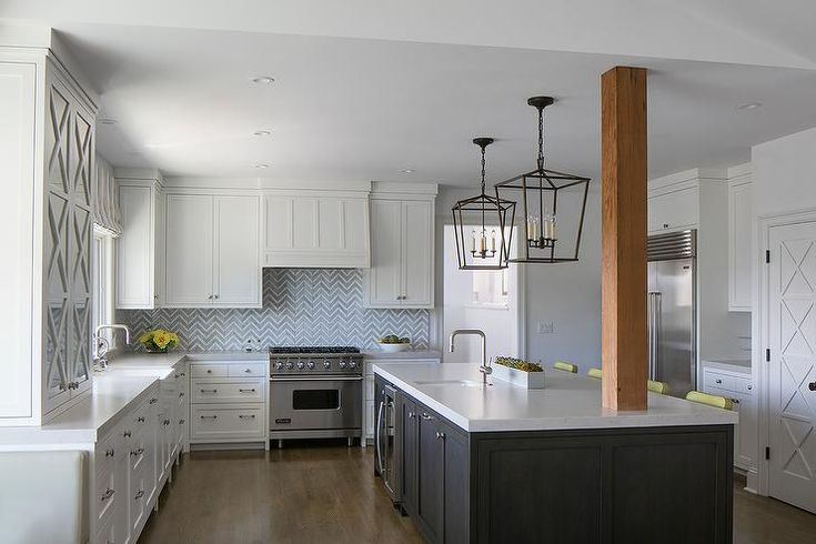 a kitchen with white cabinets and an island in the middle is seen from across the room