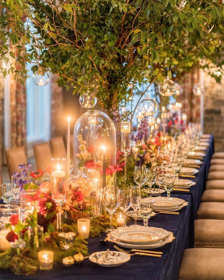 a long table is set with candles, plates and place settings for an elegant dinner