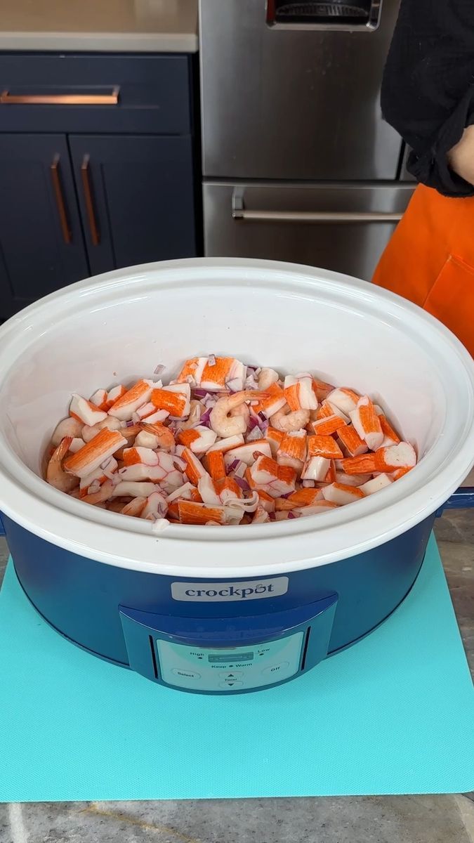 a large bowl filled with chopped carrots sitting on top of a blue countertop