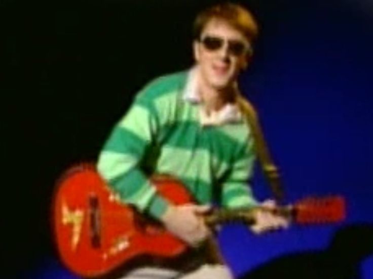 a man in sunglasses playing an electric guitar