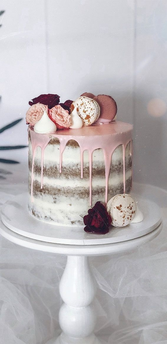 a white cake with pink icing and decorations